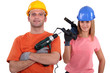 female and male tradespeople holding electric drill