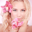 Foto: Cute girl with orchid flowers Cute girl with orchid flowers