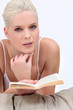 Photo: blonde woman reading a novel on a bed blonde woman reading a novel on a bed