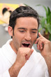 Photo: Man yawning on phone Man yawning on phone