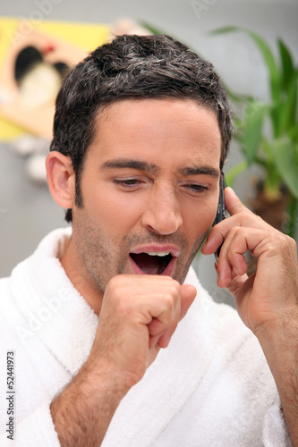 Photo: Man yawning on phone Man yawning on phone