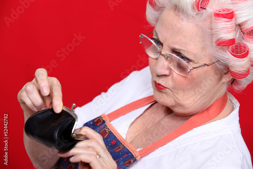 Photo: Old woman looking money in her purse Old woman looking money in her purse