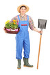 Male agricultural worker holding a shovel and flowers