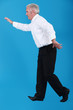 Photo: Senior businessman walking along invisible tight-rope Senior businessman walking along invisible tight-rope