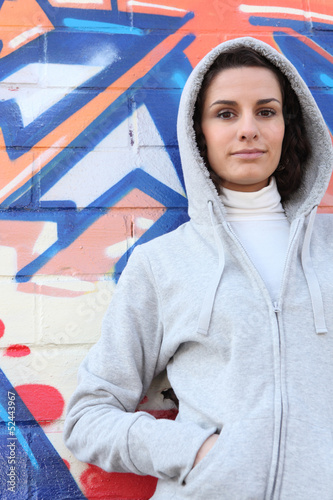 Photo: Woman standing in front of a wall Woman standing in front of a wall