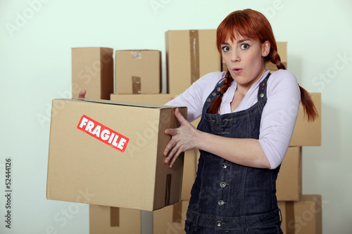 Photo: Woman carrying fragile box Woman carrying fragile box