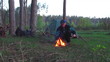 Video: man tourist is heated near a fire in wood man tourist is heated near a fire in wood
