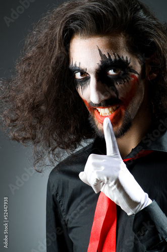 Photo: Joker personification with man in dark room Joker personification with man in dark room