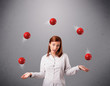 young girl standing and juggling with red balls