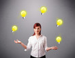 Photo: young lady standing and juggling with light bulbs young lady standing and juggling with light bulbs