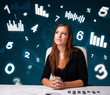Young businesswoman sitting at desk with diagrams and statistics