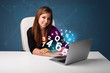 Photo: Beautiful young woman sitting at desk and typing on laptop with Beautiful young woman sitting at desk and typing on laptop with