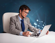 Young man sitting at dest and typing on laptop with message icon