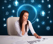 Businesswoman sitting at desk with social network icons