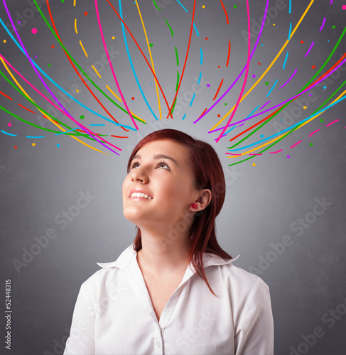 Photo: Young girl thinking with colorful abstract lines overhead Young girl thinking with colorful abstract lines overhead