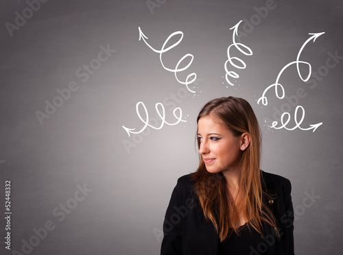 Photo: Young woman thinking with arrows overhead Young woman thinking with arrows overhead