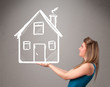 Foto: Young lady holding a huge drawn house Young lady holding a huge drawn house