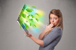Casual woman holding notebook with recycle and environmental sym