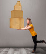 Photo: Young lady holding a set of brown cardboard boxes Young lady holding a set of brown cardboard boxes