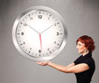 Attractive lady holding a huge clock