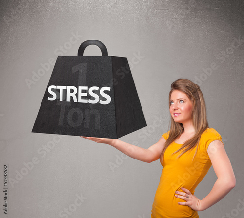 Photo: Young woman holding one ton of stress weight Young woman holding one ton of stress weight