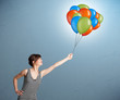 Young woman holding colorful balloons
