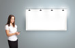 young woman standing next to a modern copy space and holding a p
