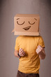 Young man gesturing with a cardboard box on his head with smiley