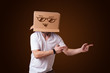 Young man gesturing with a cardboard box on his head with smiley