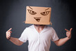 Young man gesturing with a cardboard box on his head with evil f