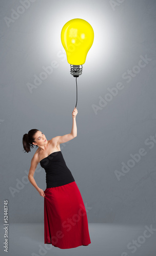 Photo: Pretty lady holding a light bulb balloon Pretty lady holding a light bulb balloon