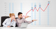Businessman and businesswoman calculating stock market with risi
