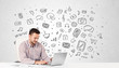 Photo: Young businessman with all kind of hand-drawn media icons in bac Young businessman with all kind of hand-drawn media icons in bac