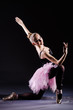 Ballerina dancing in the dark studio