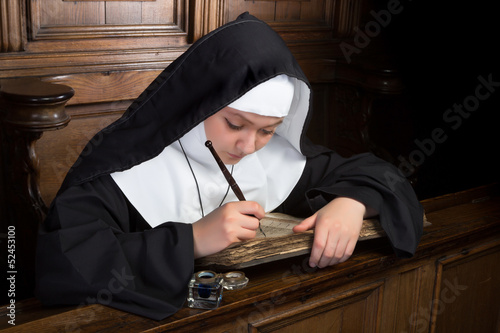 Photo: Ancient book and young nun Ancient book and young nun