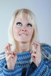 Young blond woman fingers crossed