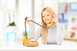 Young smiling female talking on a phone at home