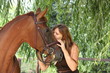 Girl in dress and brown horse portrait in forest
