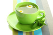 Cup of herbal tea with wild camomiles and mint, isolated