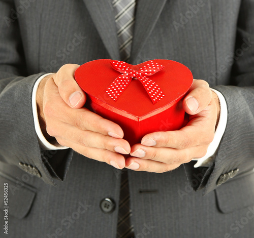 Photo: Young businessman present gift box, isolated on white Young businessman present gift box, isolated on white