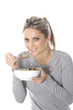 Model Released. Young Woman Eating Breakfast Cereal with Fruit