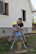 Father teaching his little son to chop firewood