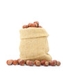 fresh hazelnuts in a bag on white background