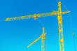 Photo: two tops of construction cranes on sky two tops of construction cranes on sky