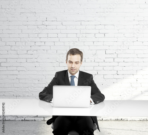 Photo: man sitting at a table man sitting at a table