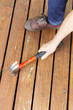 Female hand adjusting wooden cedar boards on outdoor deck