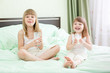 Photo: Two little girls drinking dairy on bed Two little girls drinking dairy on bed