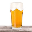 Frosty glass of light beer on a wooden table