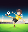 A boy in a yellow uniform playing soccer in the soccer field
