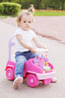 Little girl riding toy car